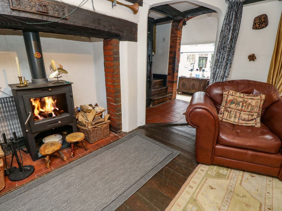 A living room with a wood stove and sofa at The Old House in Hamble