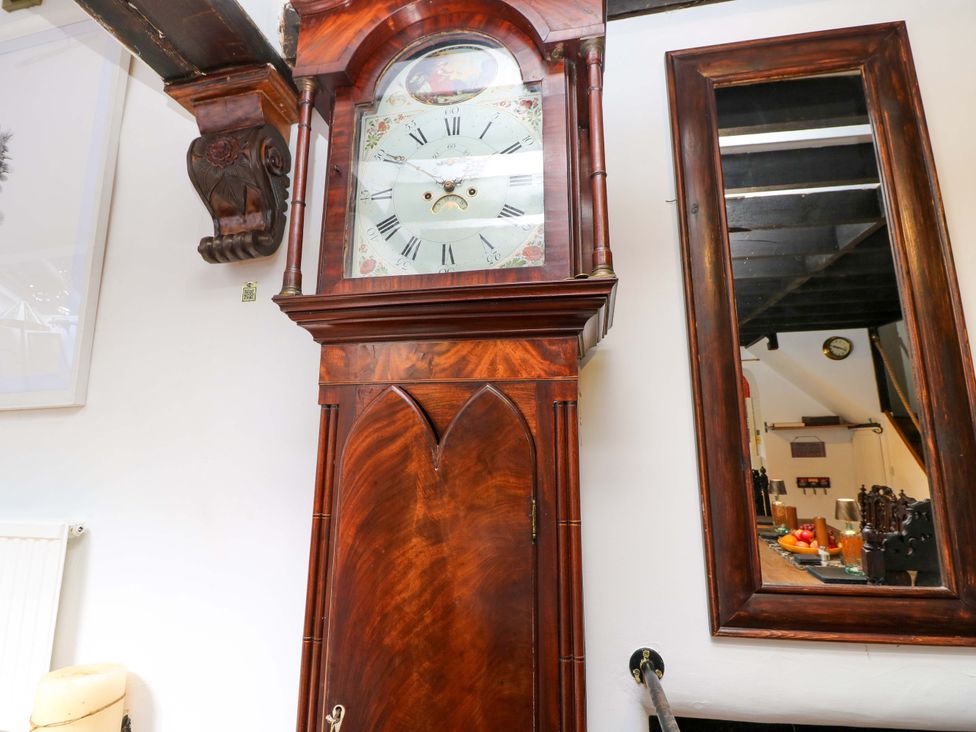 A grandfather clock and mirror in a living room at The Old House in Hamble