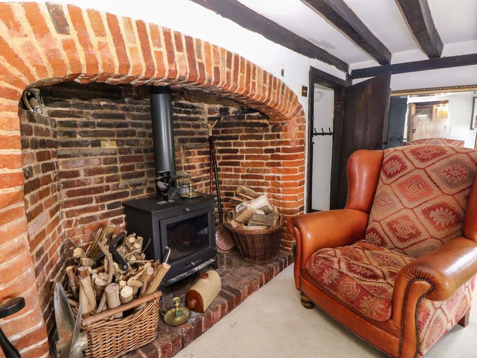A living room with a fireplace and armchair at The Old House in Hamble