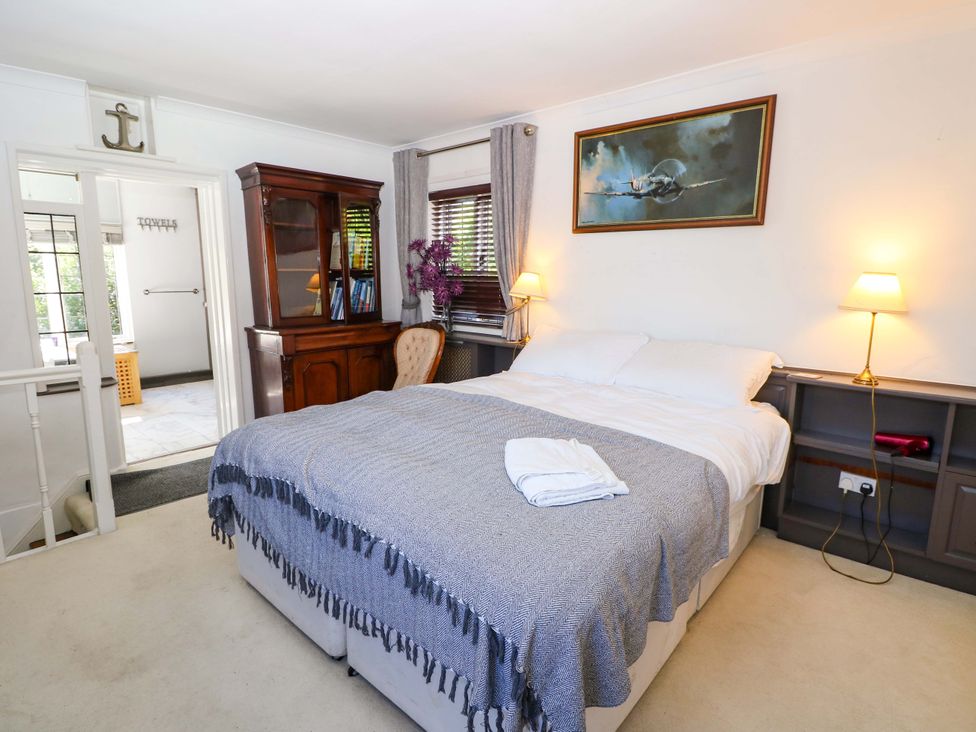 A bedroom with a bed and bookshelf at The Old House in Hamble