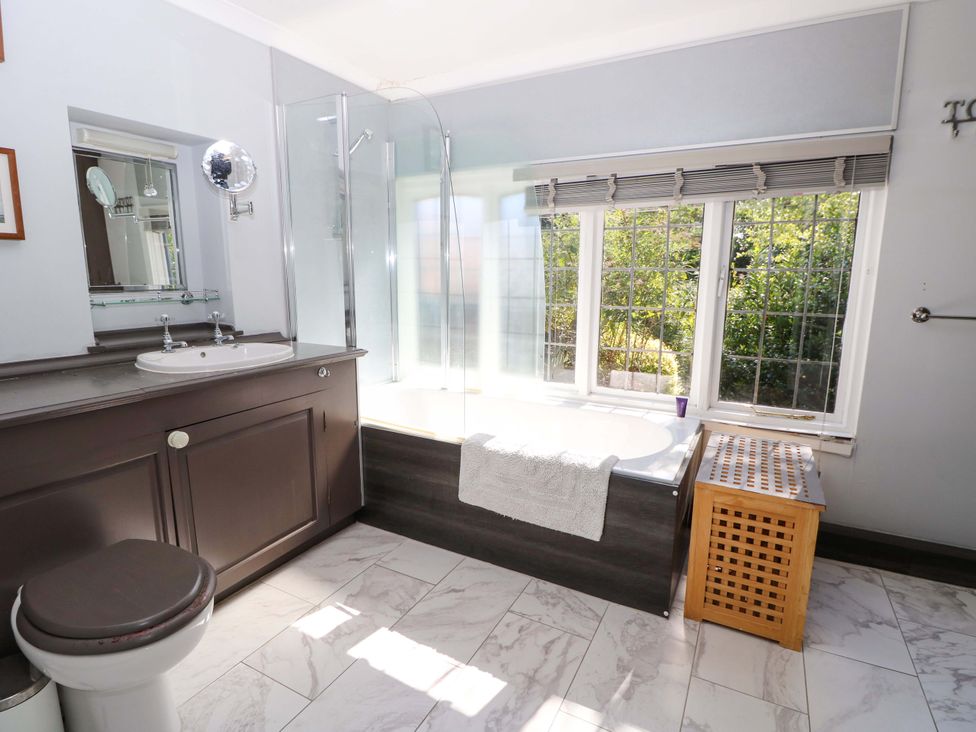 A bathroom with sink, shower, bathtub, and window at The Old House in Hamble