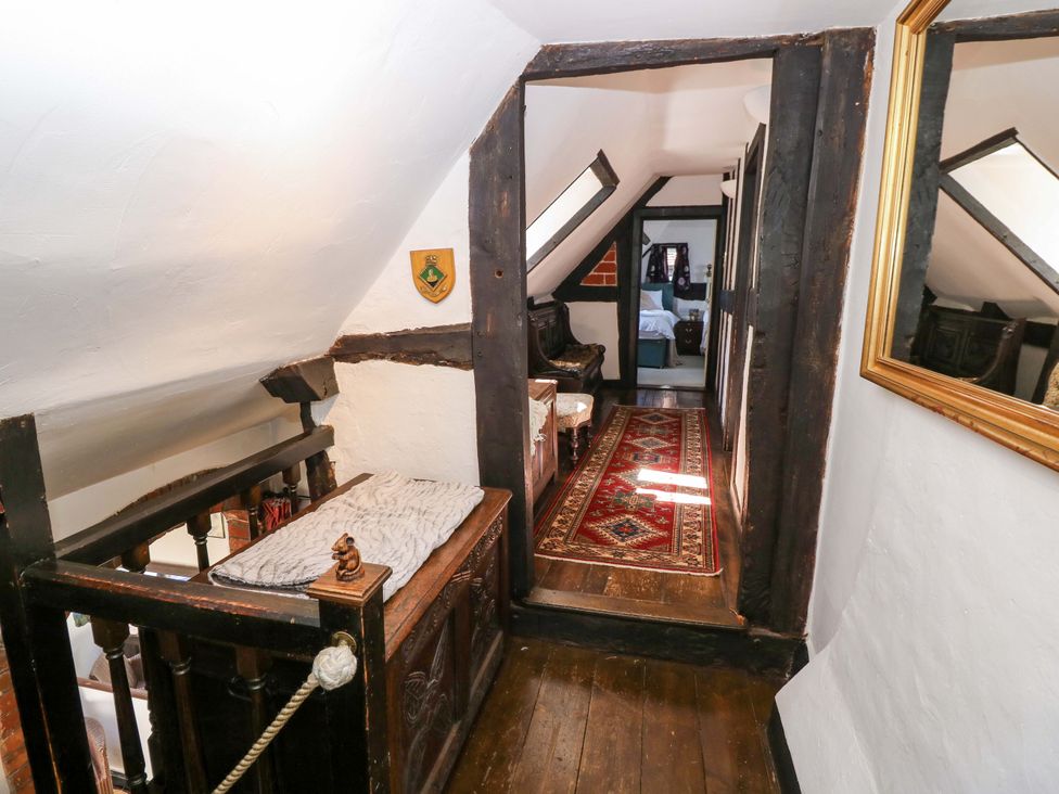 A hallway with wooden railing and rug at The Old House in Hamble