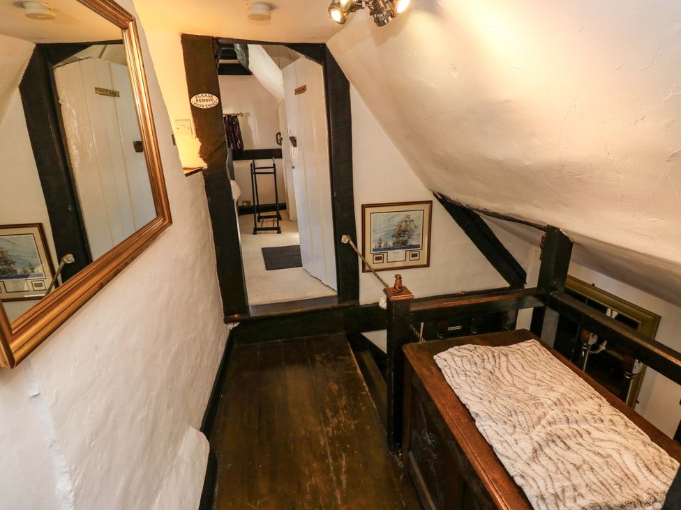 A hallway with a mirror and a painting at The Old House in Hamble