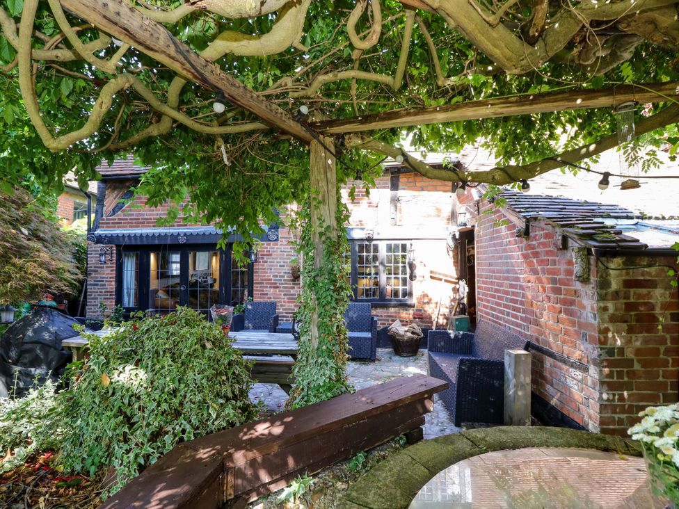 A garden with outdoor seating and a brick wall at The Old House in Hamble