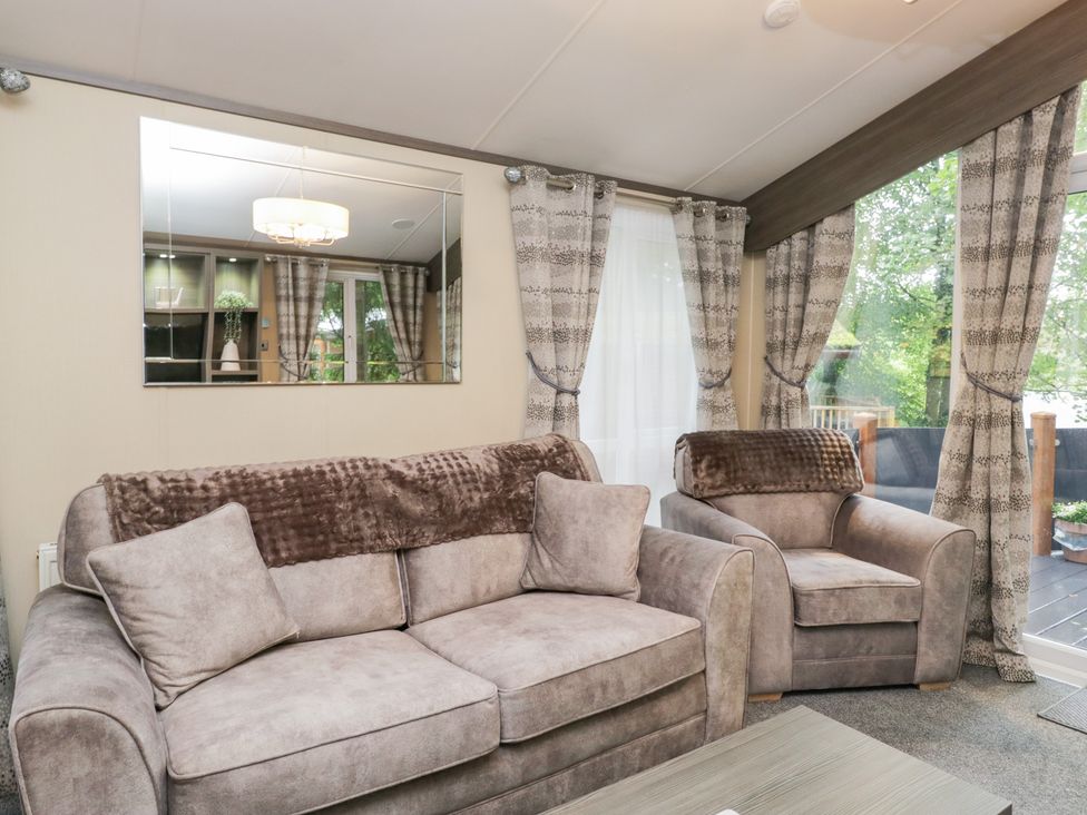 A living room with sofa and armchairs at Feather Hill Lodge in Windermere