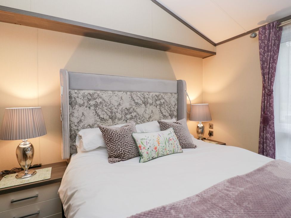 A bedroom with a bed and lamps at Feather Hill Lodge in Windermere