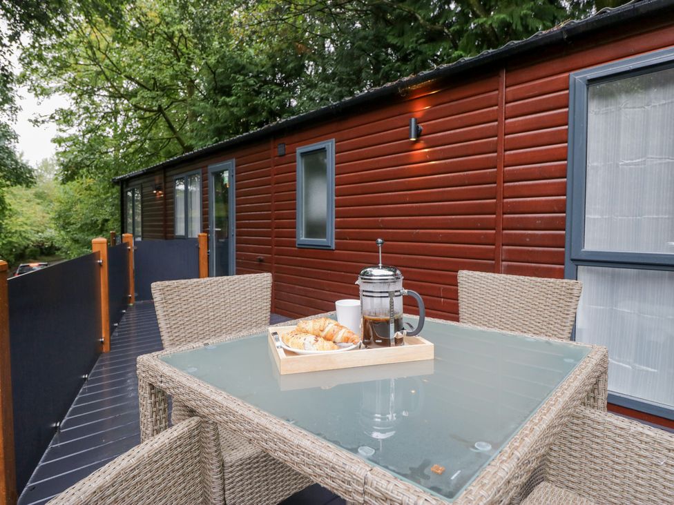 An outdoor deck with a table and food items at Feather Hill Lodge in Windermere
