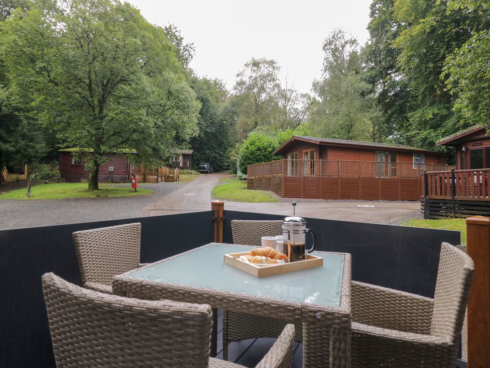 An outdoor seating area with a table and chairs at Feather Hill Lodge in Windermere