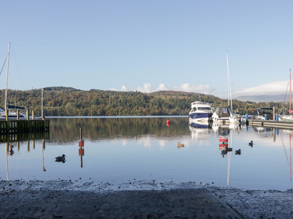 A view of a lake with boats and birds at Feather Hill Lodge White Cross Bay near Troutbeck Bridge