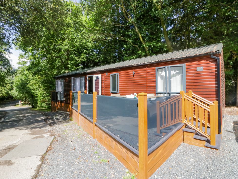 An outdoor view of a cabin with a deck at Feather Hill Lodge White Cross Bay near Troutbeck Bridge