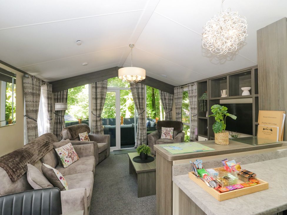 A living room with sofas and a coffee table at Feather Hill Lodge White Cross Bay near Troutbeck Bridge
