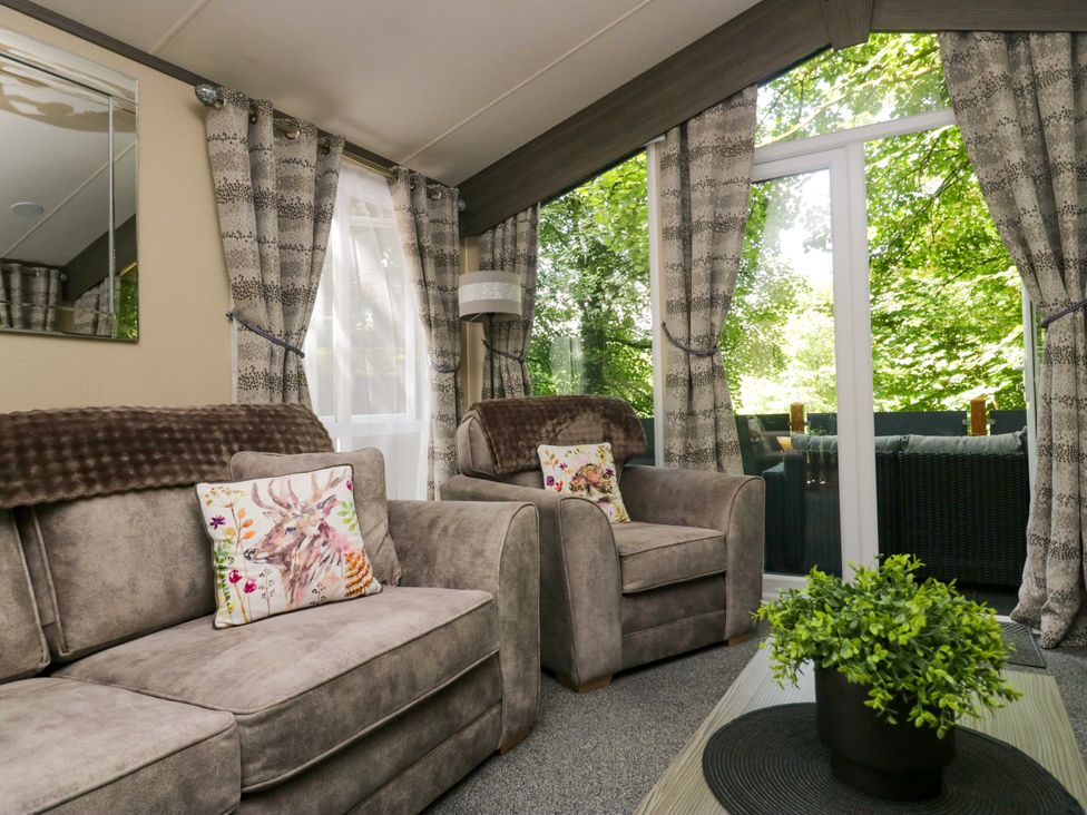 A living room with two armchairs and a table at Feather Hill Lodge White Cross Bay, Skiptory Howe 38 near White Cross Bay