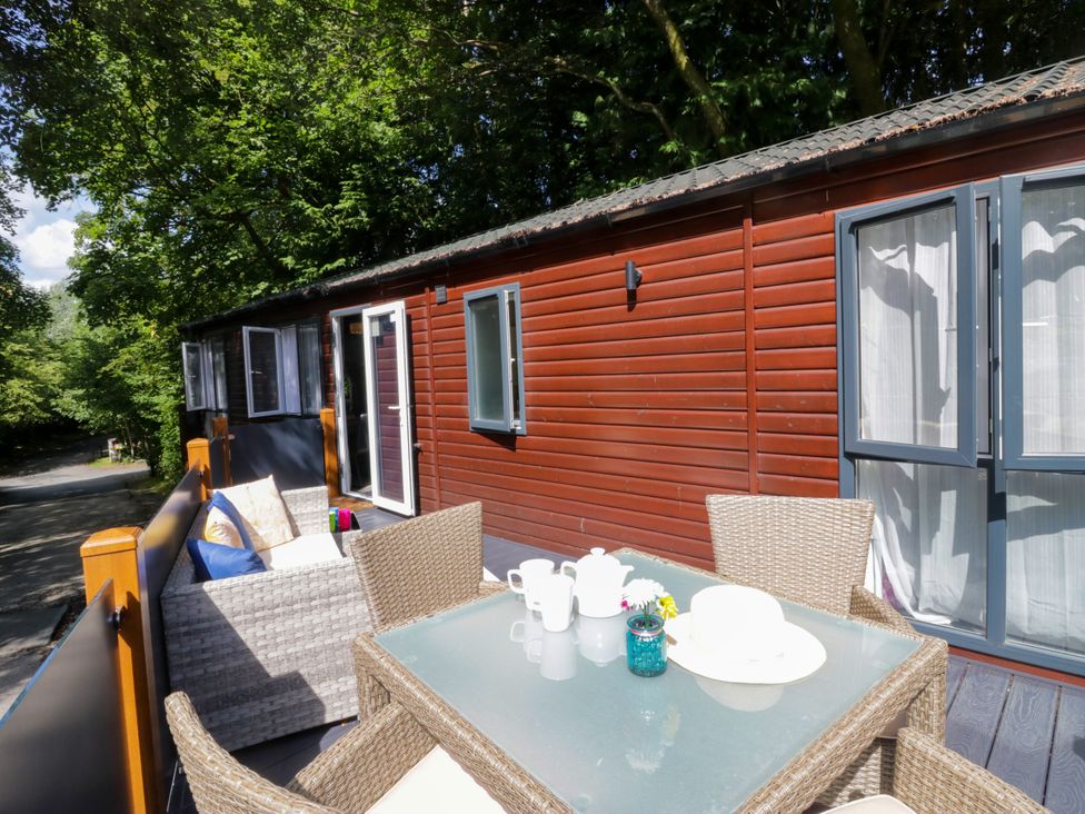 An outdoor seating area with a table and chairs at Feather Hill Lodge White Cross Bay, Skiptory Howe 38 near Troutbeck Bridge