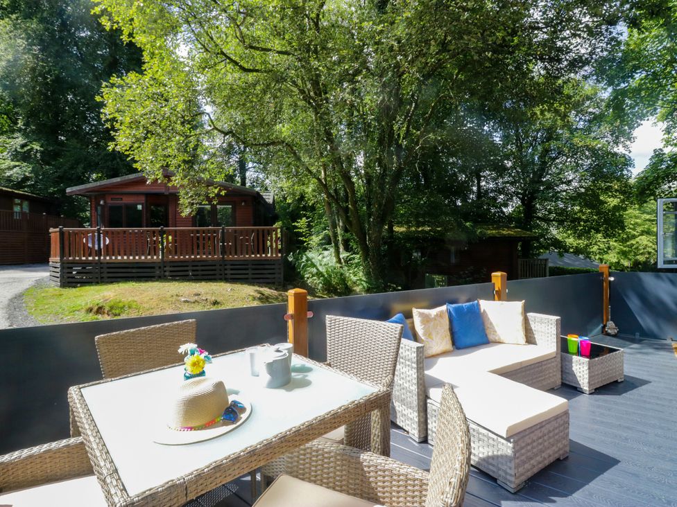 An outdoor seating area with a table and chairs at Feather Hill Lodge White Cross Bay, Skiptory Howe 38 near Troutbeck Bridge