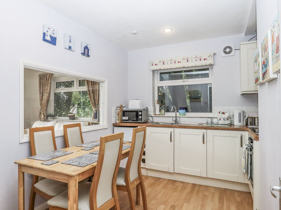 A kitchen with a table and chairs at Mayflower View in Dawlish