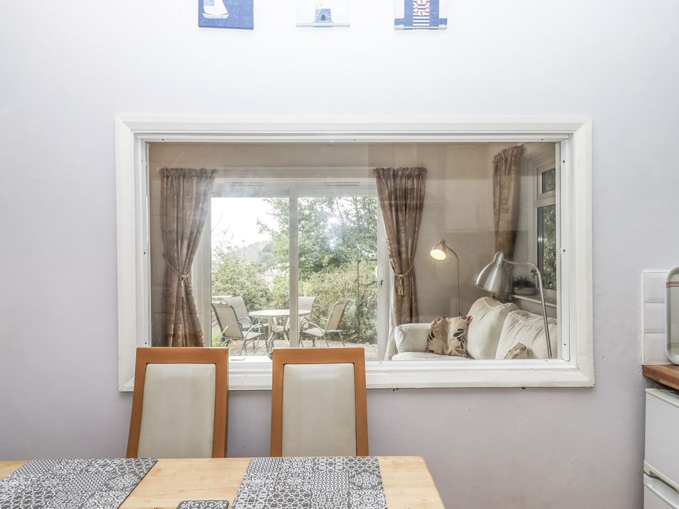 A dining room with a view of a living area at Mayflower View in Dawlish