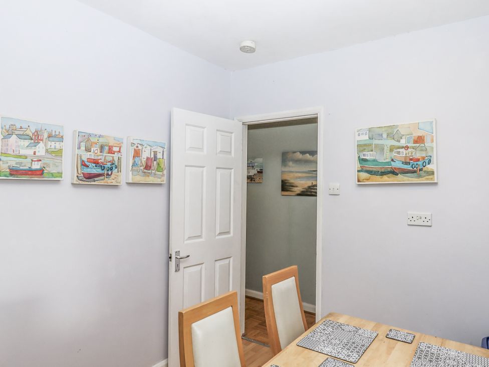 A dining room with a table and chairs at Mayflower View in Dawlish