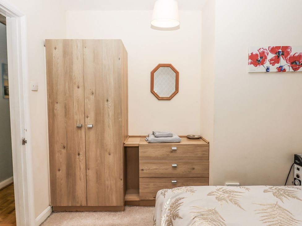 A bedroom with wardrobe and chest of drawers at Mayflower View in Dawlish