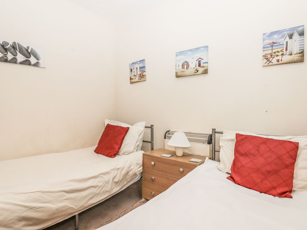 A bedroom with two beds and a nightstand at Mayflower View in Dawlish