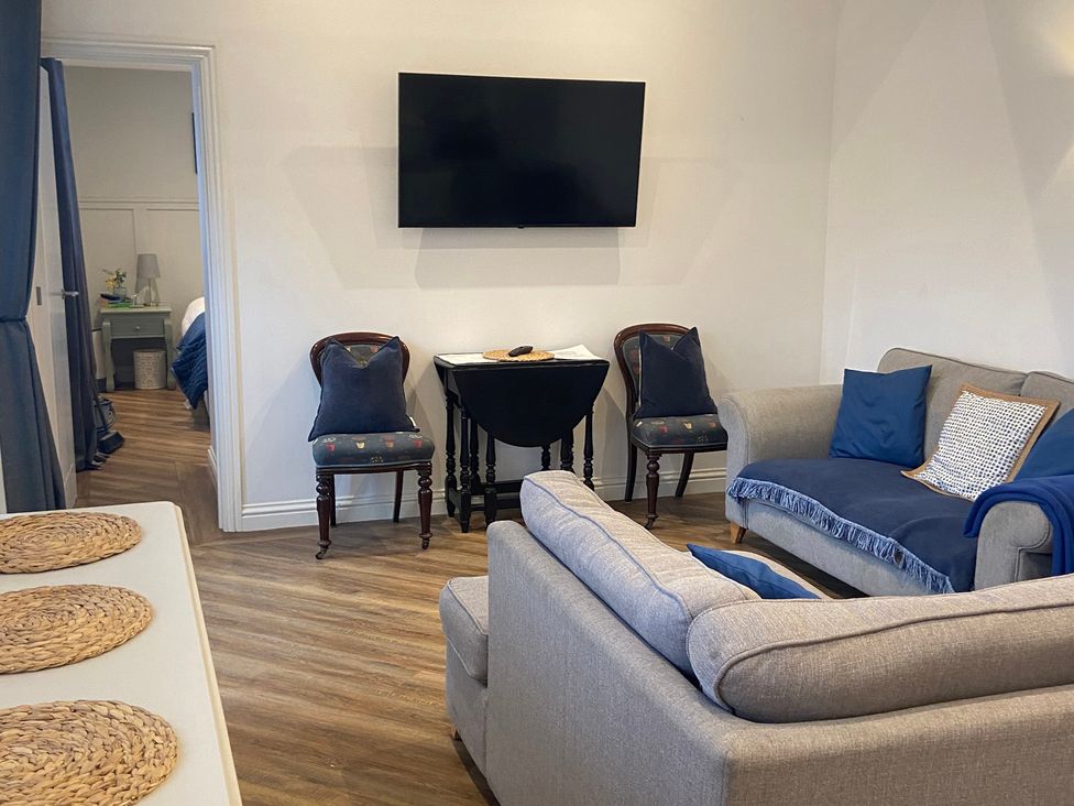 A living room with a sofa and TV at The Cart Shed in Bedford