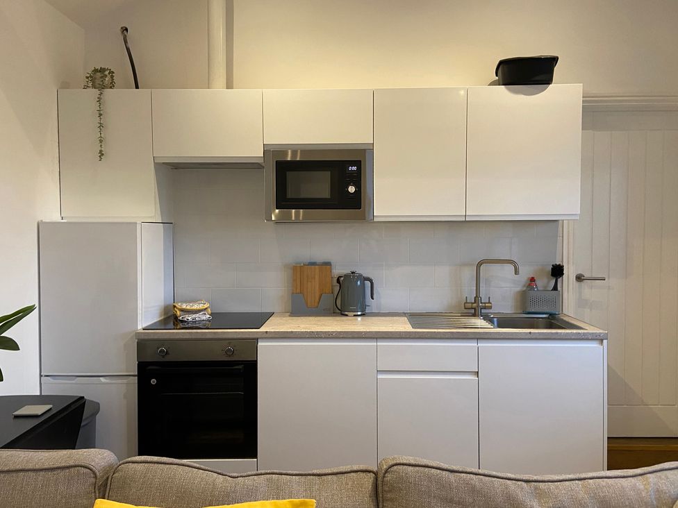 A kitchen with cabinets, sink, and appliances at The Cart Shed in Bedford