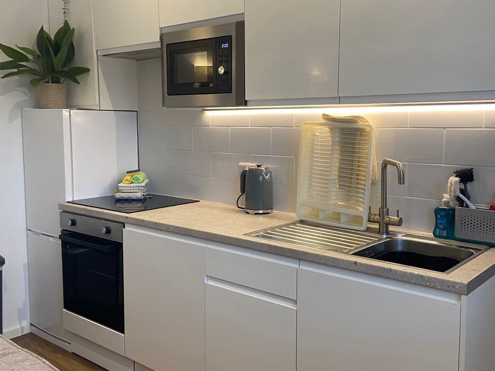 A kitchen with appliances and dish rack at The Cart Shed in Bedford