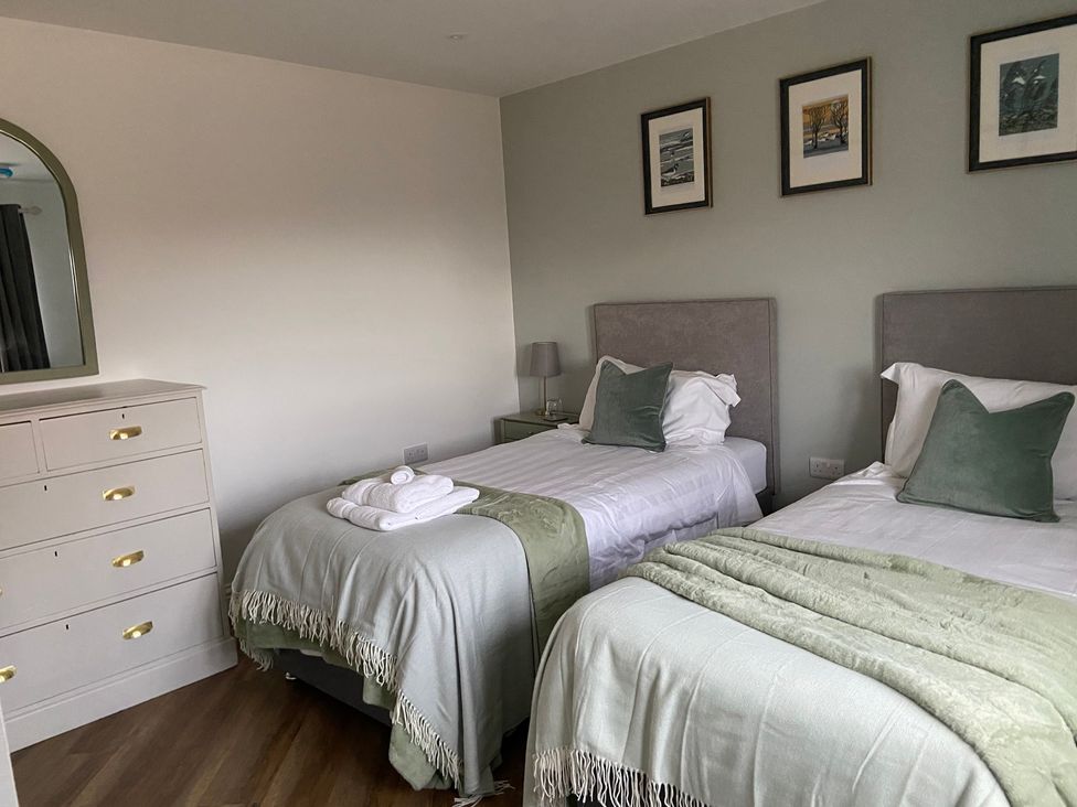 A bedroom with two beds and a dressing table at The Cart Shed in Bedford