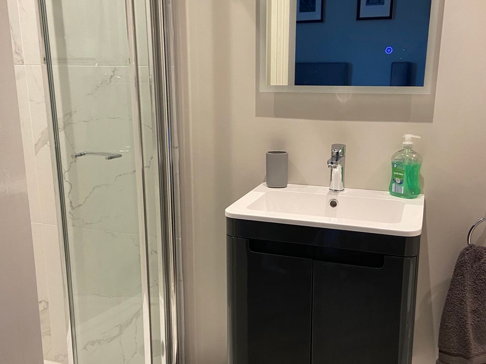 A bathroom with a shower and sink at The Cart Shed in Bedford
