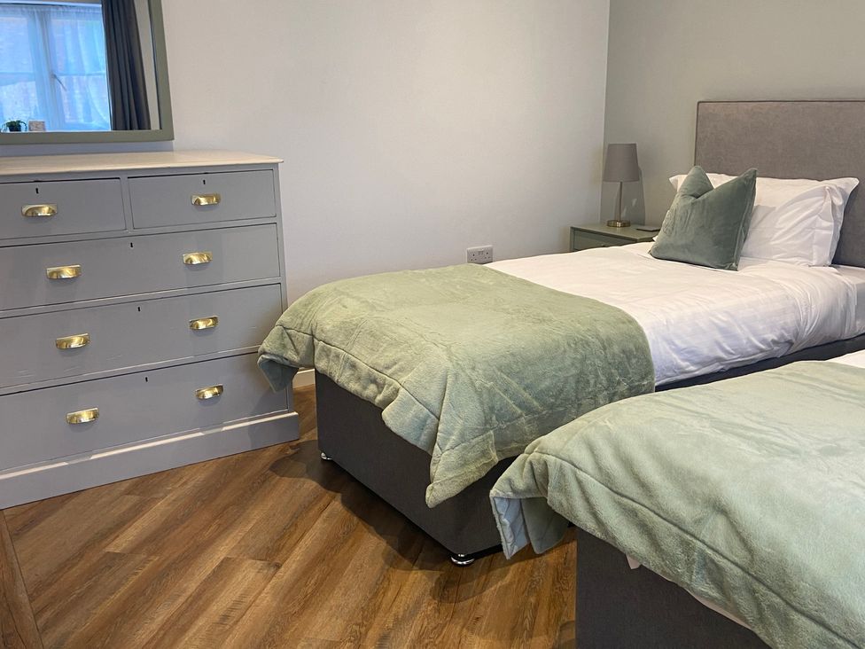 A bedroom with two beds and a dresser at The Cart Shed in Bedford