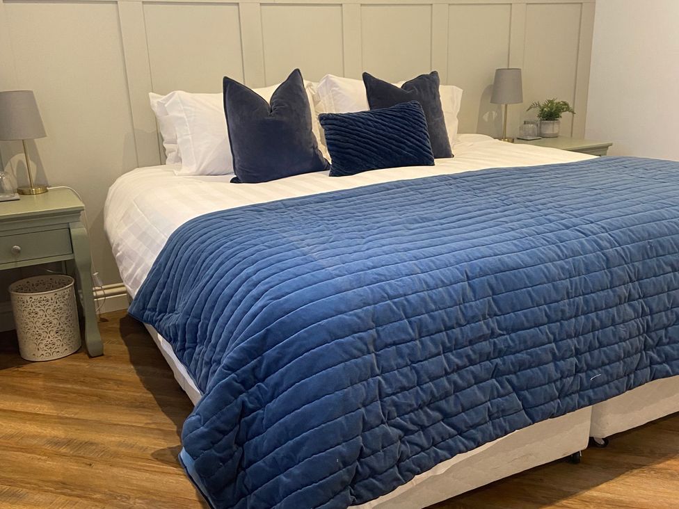 A bedroom with a bed and bedside table at The Cart Shed Bedford