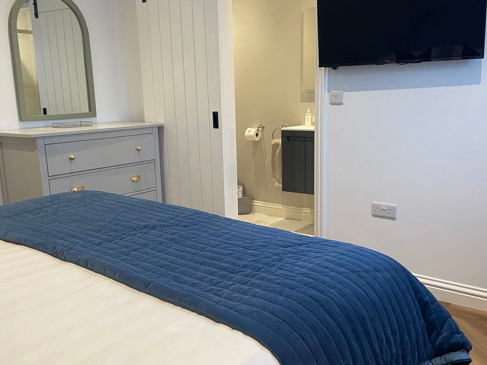 A bedroom with a bed and a dresser at The Cart Shed in Bedford
