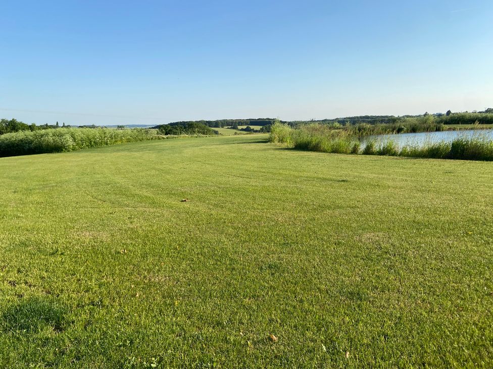 An outdoor area with grass and a pond at The Cart Shed in Bedford
