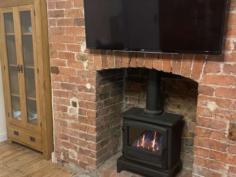 A living room with a fireplace and a television at 15A Currier Lane Ashton-under-Lyne