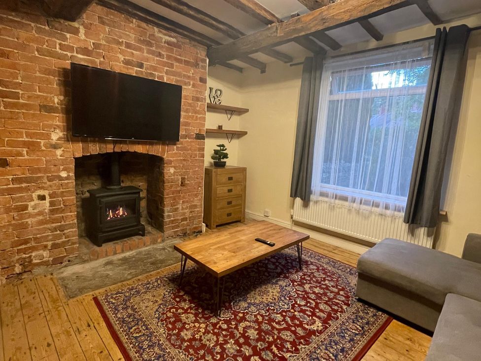 A living room with a brick wall and a fireplace at 15A Currier Lane Ashton-under-Lyne