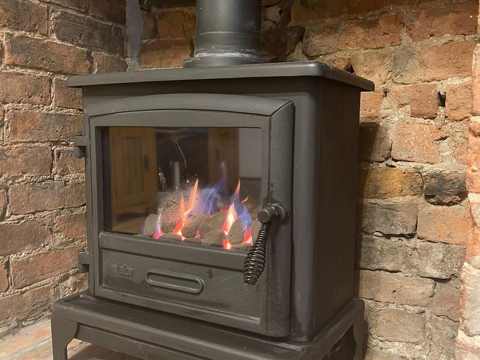 A stove with flames in a living room at 15A Currier Lane Ashton-under-Lyne