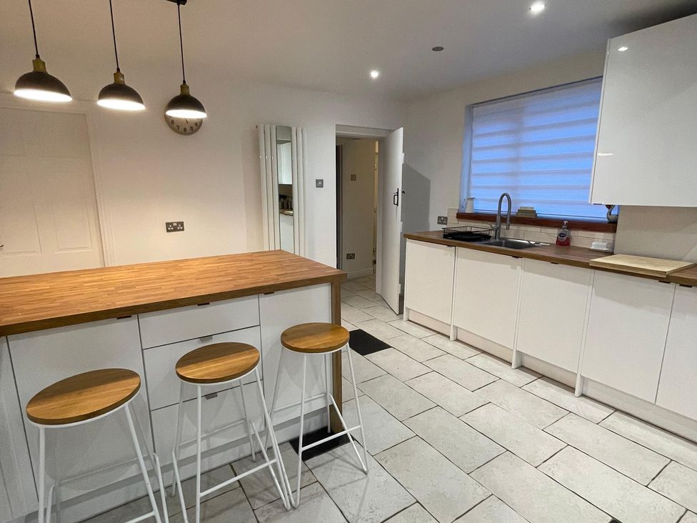 A kitchen featuring an island with bar stools and a sink at 15A Currier Lane Ashton-under-Lyne