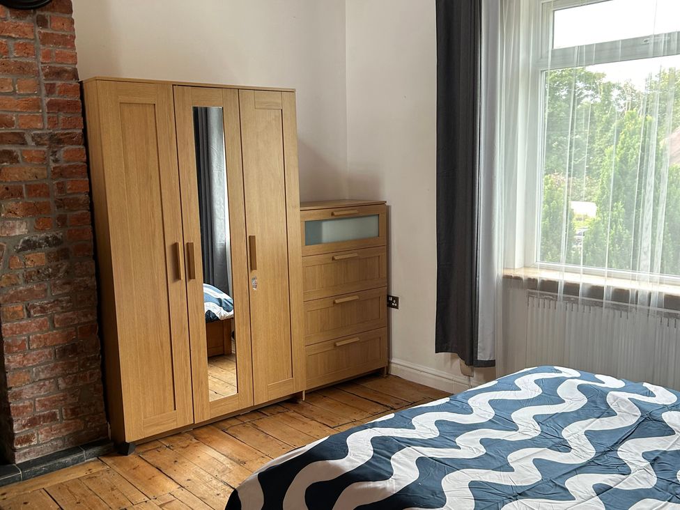 A bedroom with a wardrobe and bed at 15A Currier Lane Ashton-under-Lyne