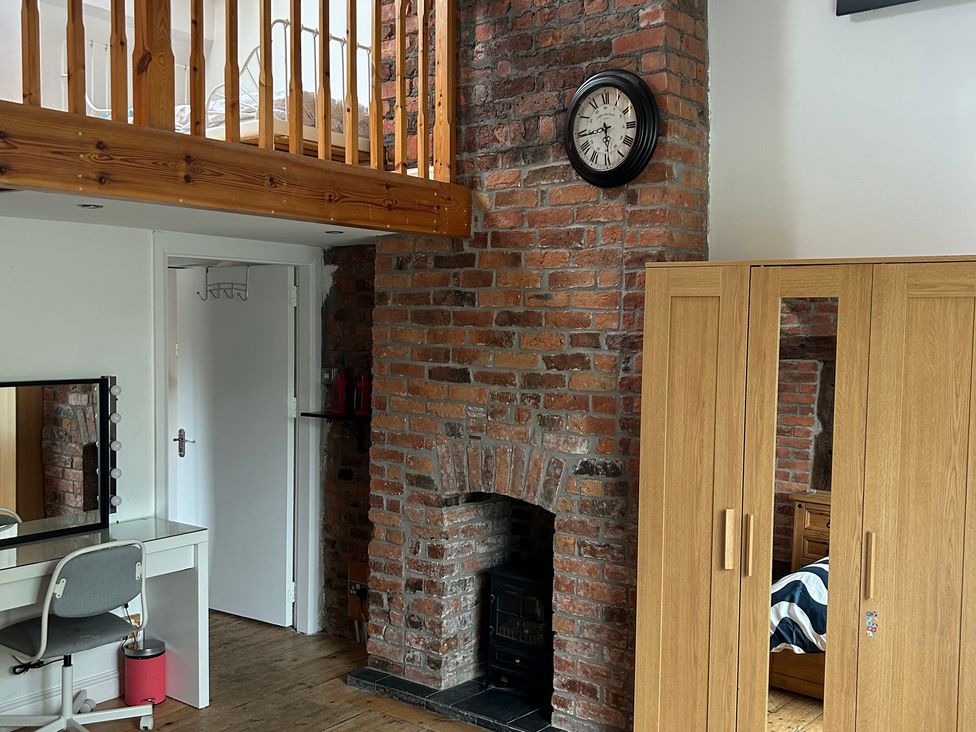 A bedroom with a brick wall and a balcony at 15A Currier Lane Ashton-under-Lyne