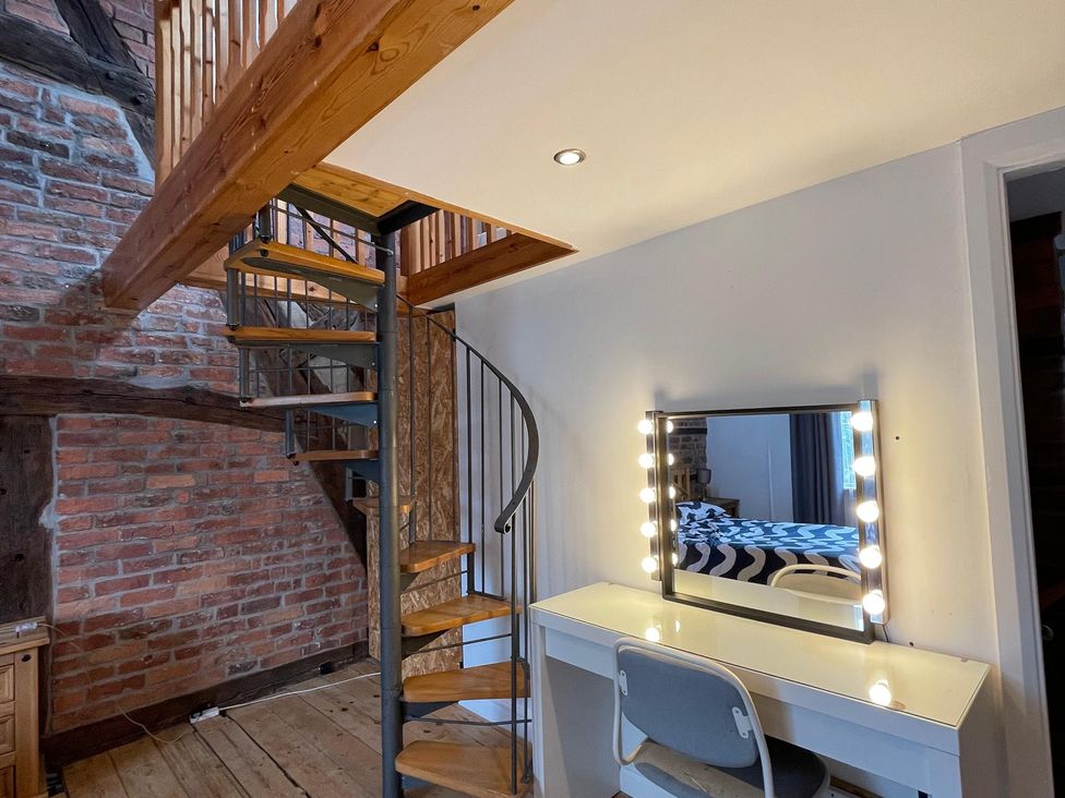 A room with a spiral staircase and a vanity desk at 15A Currier Lane Ashton-under-Lyne