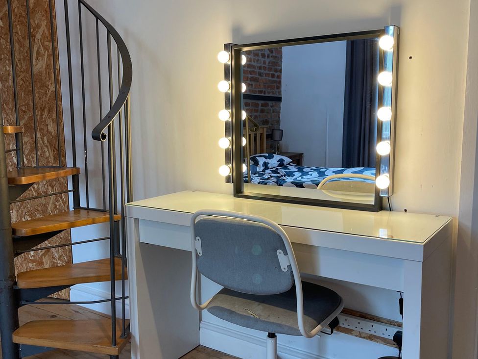 A vanity table with a mirror and a chair in a bedroom at 15A Currier Lane Ashton-under-Lyne