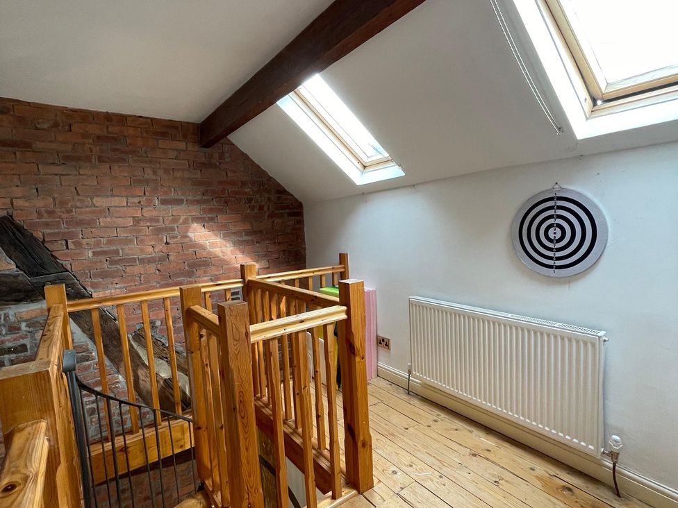 A landing with a wooden railing and dartboard at 15A Currier Lane Ashton-under-Lyne