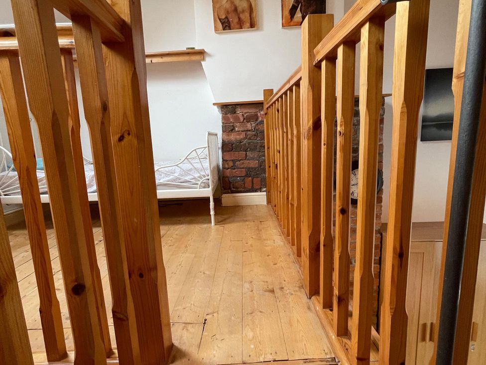 A hallway with wooden railing and a bed at 15A Currier Lane Ashton-under-Lyne