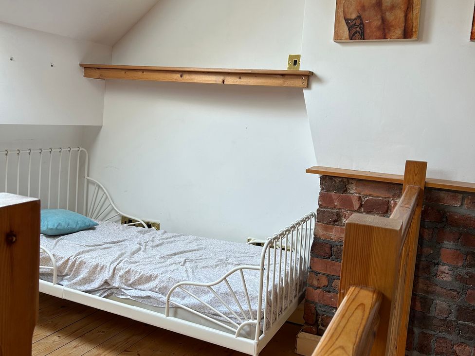 A bedroom with a bed and a shelf at 15A Currier Lane Ashton-under-Lyne