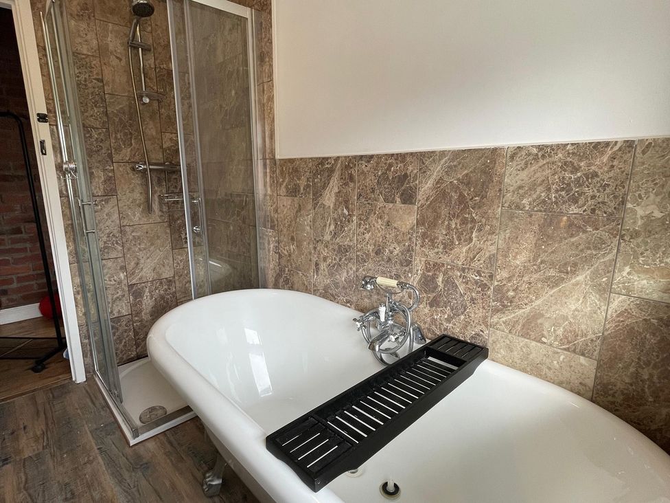 A bathroom with a bathtub and shower at 15A Currier Lane Ashton-under-Lyne