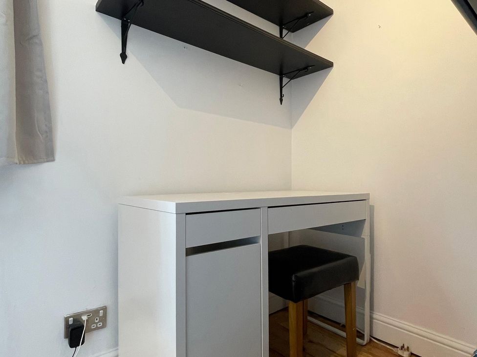 A desk with a stool and shelves at 15A Currier Lane Ashton-under-Lyne