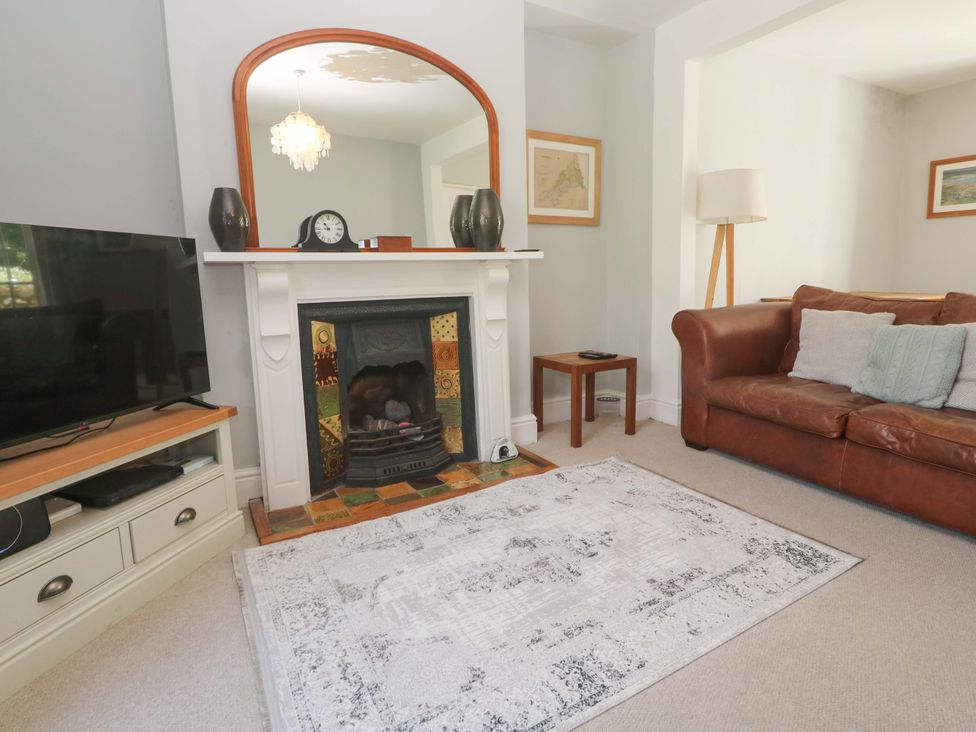 A living room with a television, fireplace, and sofa at Pedn Brose Near Mousehole