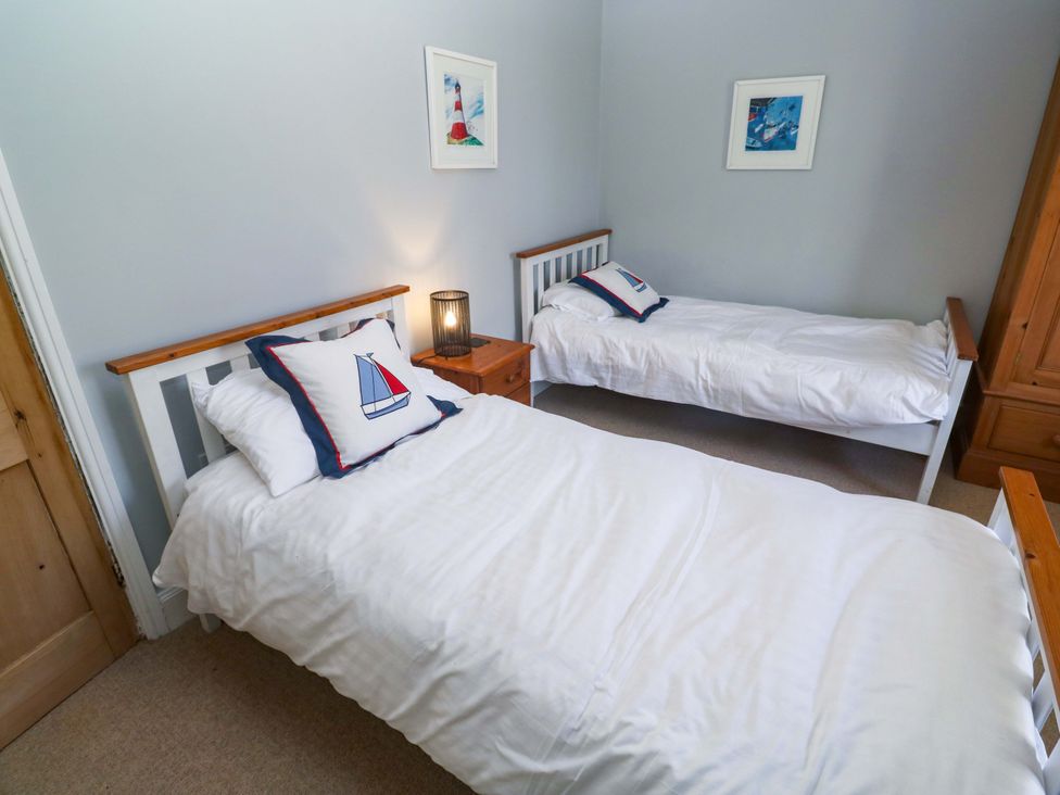 A bedroom with two single beds and a nightstand at Pedn Brose Near Mousehole