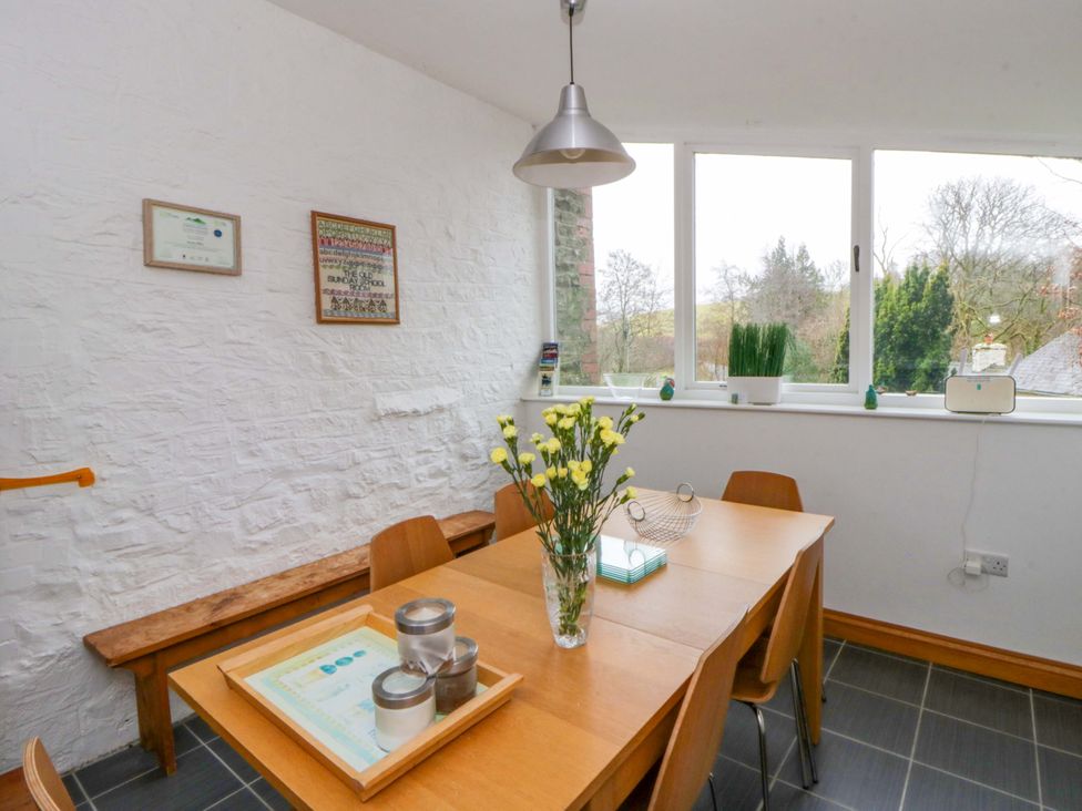A dining room with a table and chairs at The Old Sunday School near Cwmwysg