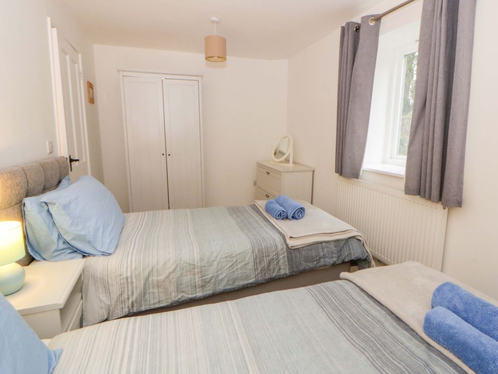 A bedroom with two beds and a cupboard at The Old Sunday School in Cwmwysg near Sennybridge