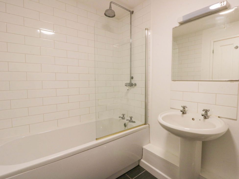 A bathroom with a bath tub and sink at The Old Sunday School in Cwmwysg near Sennybridge